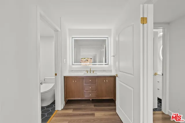 a bathroom with a sink a toilet and a mirror