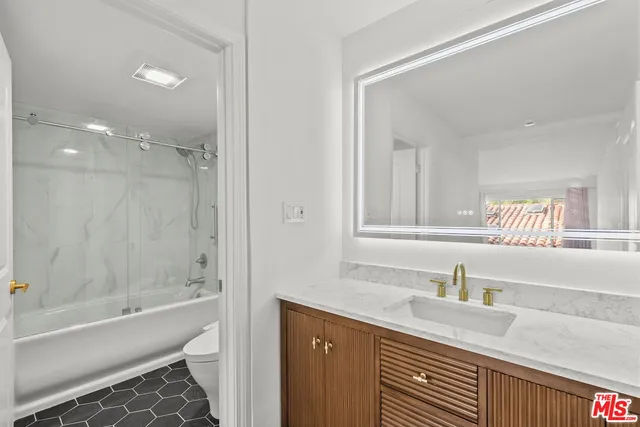 a bathroom with a granite countertop sink a bathtub and a shower