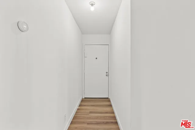 a view of a hallway with wooden floor