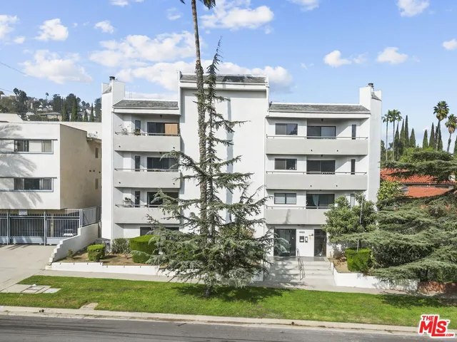a front view of a residential apartment building with a yard