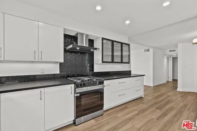 a kitchen with granite countertop white cabinets and stainless steel appliances