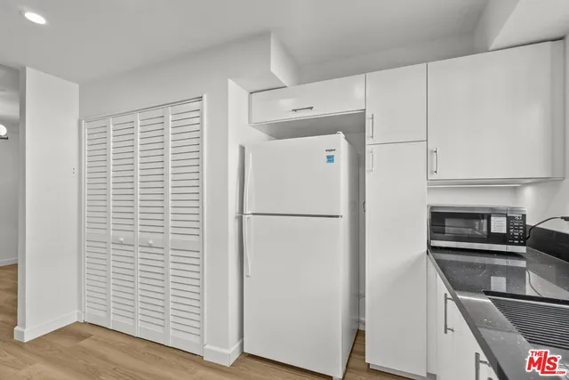a white refrigerator freezer and a stove sitting inside of a kitchen