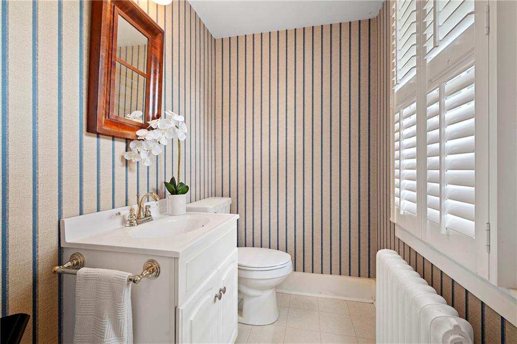 212 Pine Road Sewickley, PA 15143 - Photo 15 of 33 The first-floor powder room features a clean, updated vanity and classic finishes with natural light from a window with plantation shutters.