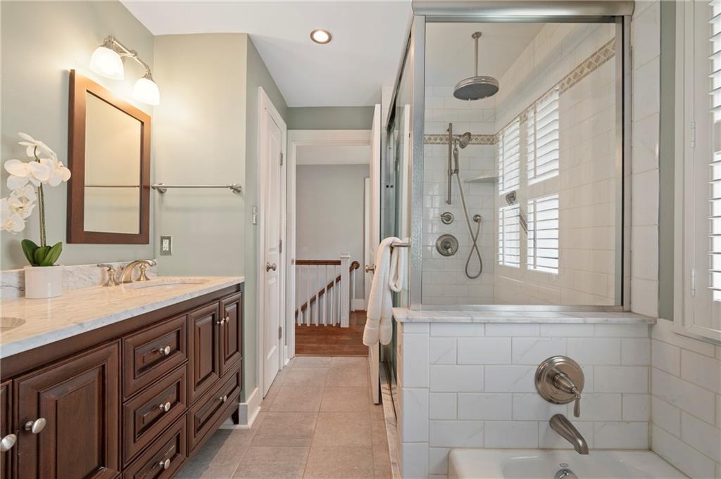 212 Pine Road Sewickley, PA 15143 - Photo 21 of 33 This bathroom combines a double vanity with a tub and glass-enclosed shower, offering flexibility for both quick routines and more relaxed use. Thoughtful layout and natural light create a comfortable, easy-to-use space.