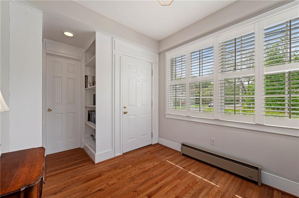 212 Pine Road Sewickley, PA 15143 - Photo 5 of 33 Bright foyer with hardwood floors, plantation shutters, and two sets of built-in bookshelves for added charm and everyday storage.