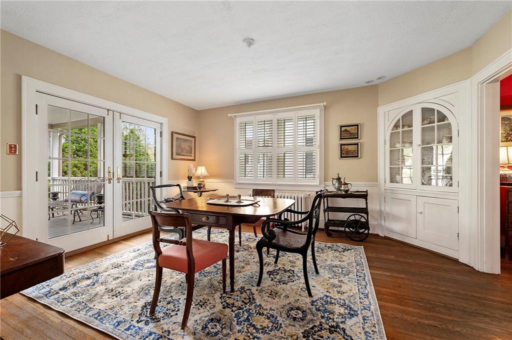212 Pine Road Sewickley, PA 15143 - Photo 6 of 33 Dining room with hardwood floors and plantation shutters, seamlessly connecting to the kitchen and living areas for easy flow. French doors open to a covered back deck, creating an ideal setting for indoor-outdoor dining and entertaining.