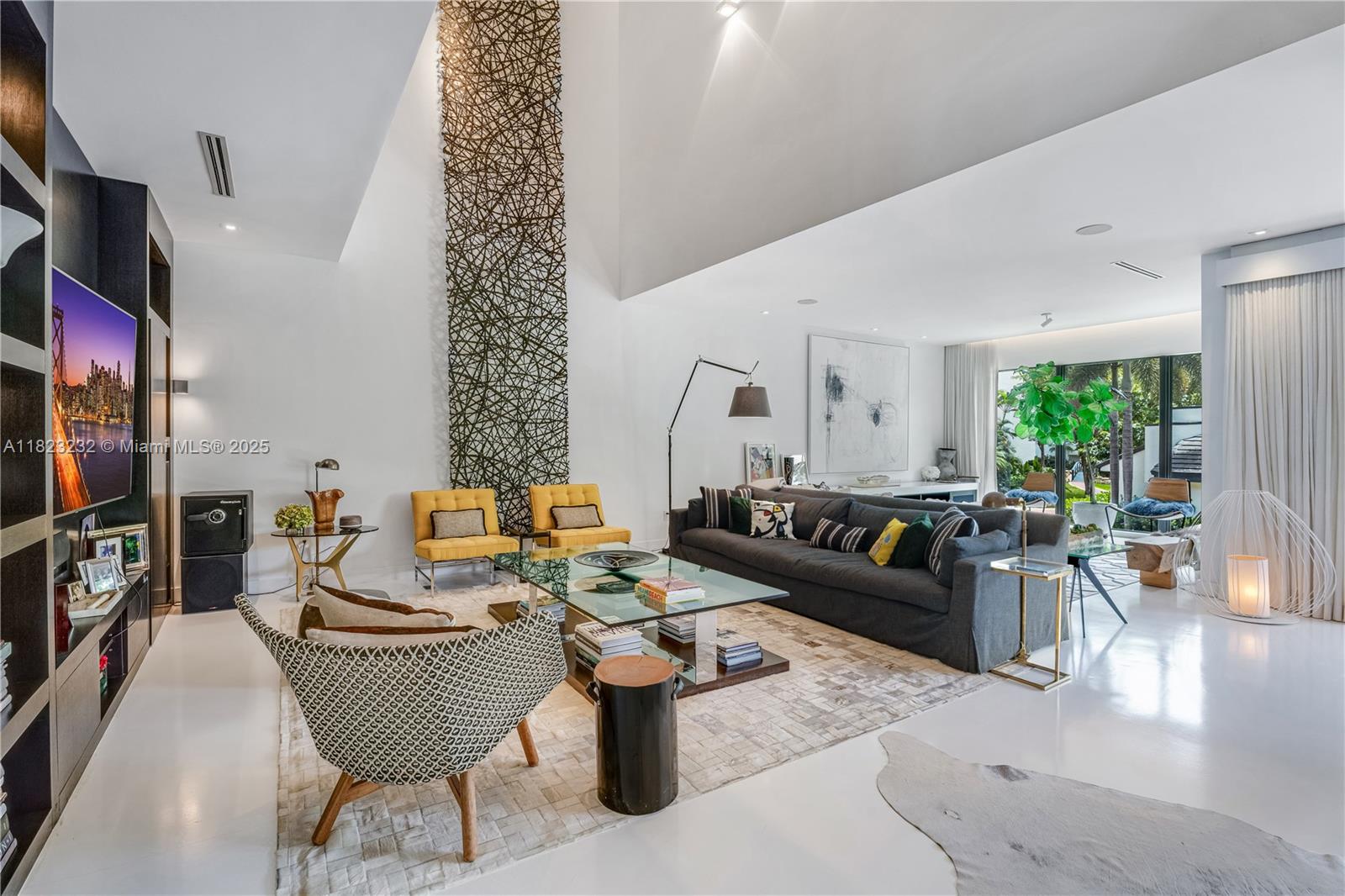 a living room with furniture a window and a flat screen tv