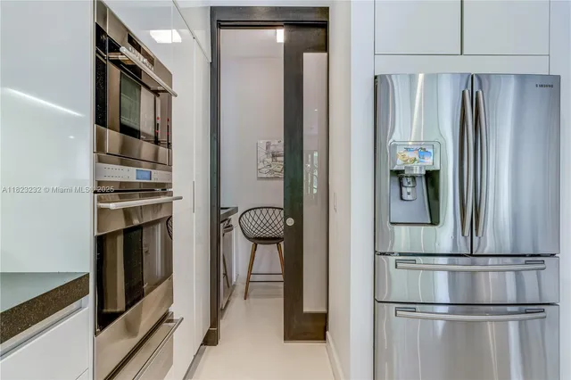 a view of kitchen with stainless steel appliances granite countertop a refrigerator and a stove top oven