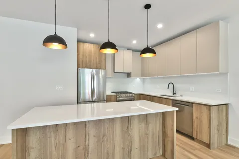 a kitchen with a stove a kitchen island a sink and a window