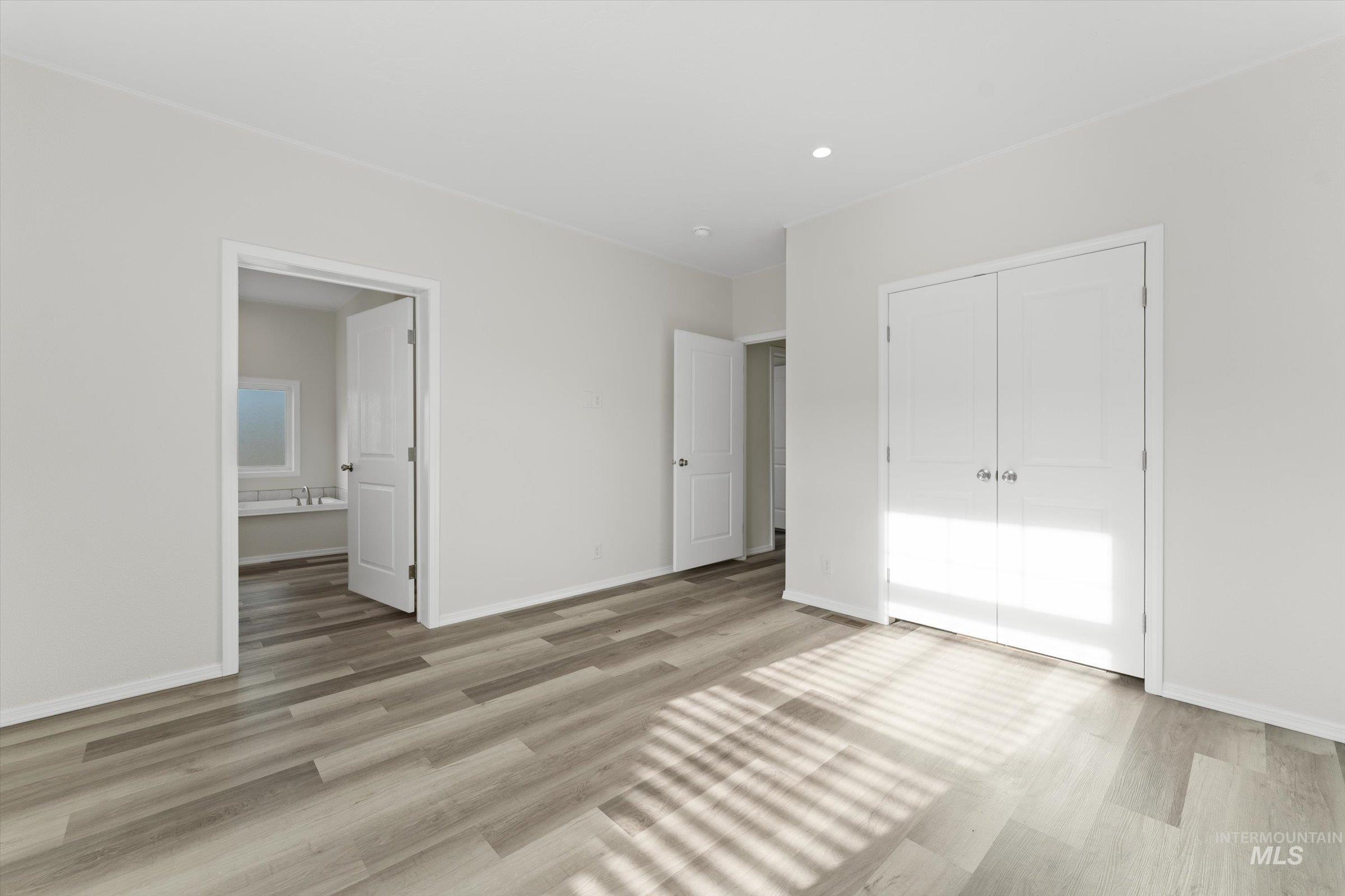 421 South Curtis Road, Unit 34 34 Boise, ID 83705 - Photo 17 of 22 Unfurnished bedroom with light wood finished floors, a closet, and ensuite bathroom