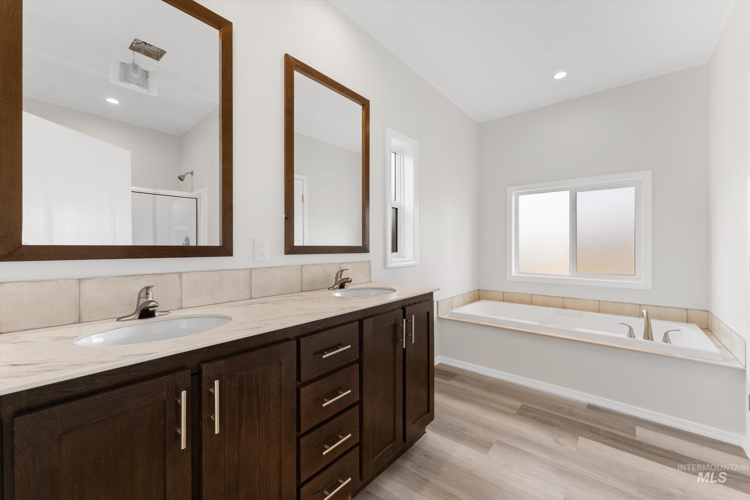 421 South Curtis Road, Unit 34 34 Boise, ID 83705 - Photo 18 of 22 Bathroom with a bath, double vanity, a shower stall, light wood-style floors, and recessed lighting