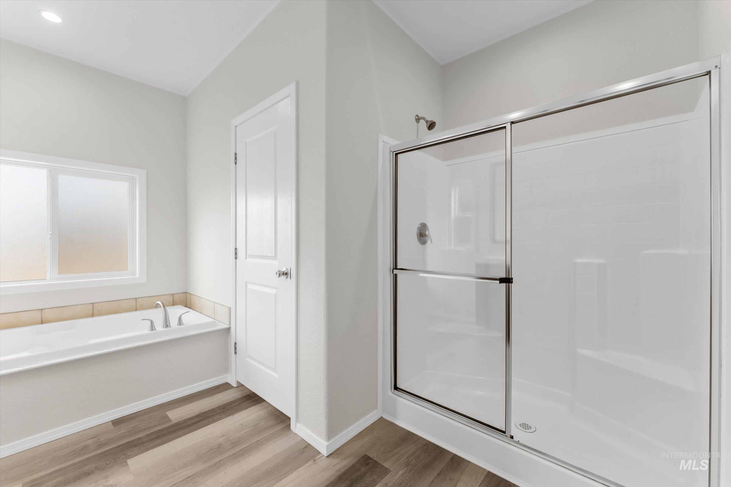 421 South Curtis Road, Unit 34 34 Boise, ID 83705 - Photo 19 of 22 Bathroom featuring a shower stall, light wood-style floors, and a garden tub