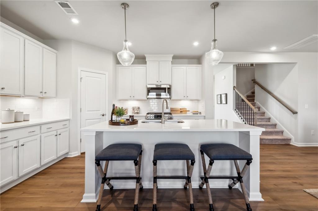 318 Cavalier Lane Acworth, GA 30102 - Photo 9 of 47 a kitchen with granite countertop white cabinets and stainless steel appliances