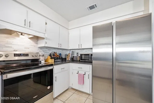 a kitchen with granite countertop stainless steel appliances cabinets and a counter top space