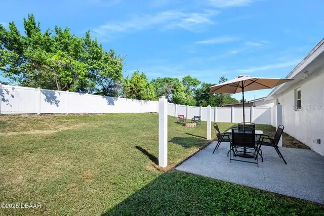 a view of a patio with furniture and a yard