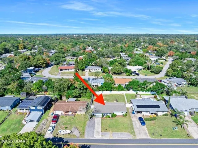 an aerial view of residential houses with outdoor space and ocean view