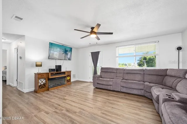a living room with furniture and a wooden floor