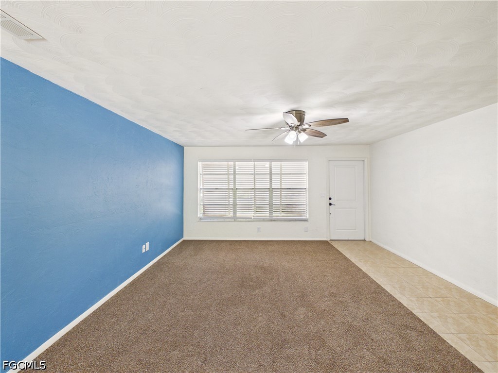 18541 Iris Road Fort Myers, FL 33967 - Photo 4 of 18 an empty room with windows and chandelier fan