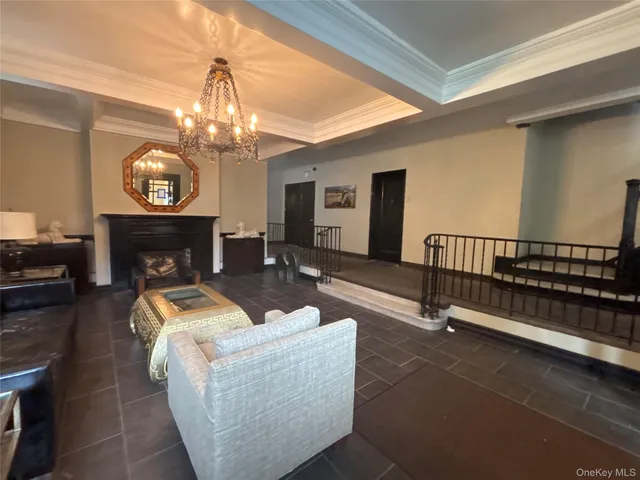 a living room with furniture a fireplace and a chandelier