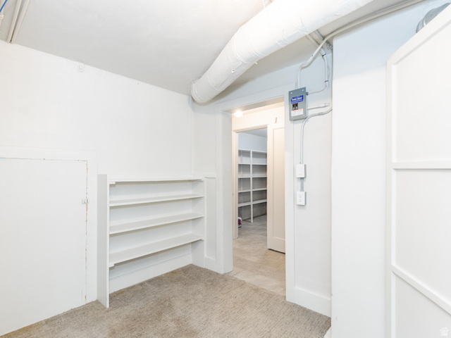 227 West 200 North Logan, UT 84321 - Photo 34 of 44 Carpeted room with built-in shelving, white walls, and a white ceiling featuring exposed ductwork