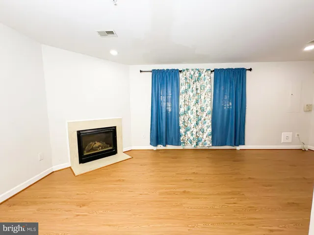 a view of an empty room with a fireplace and a window