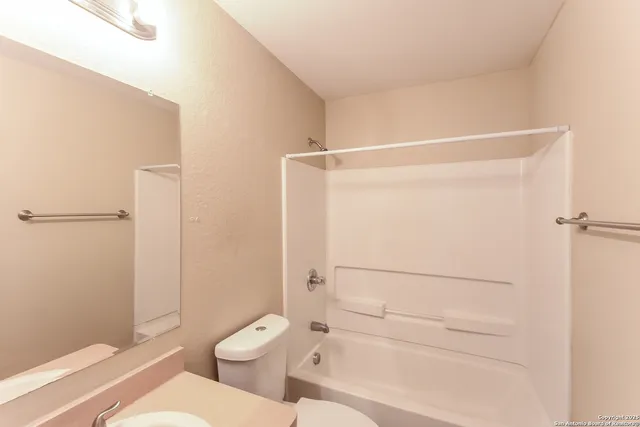 a bathroom with a granite countertop shower and a toilet