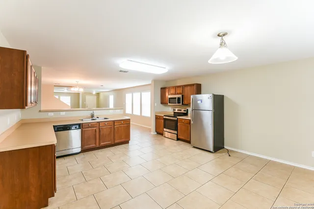 a large kitchen with stainless steel appliances a sink a counter top space cabinets and stainless steel appliances