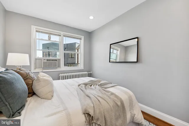 a bedroom with a bed and a large window