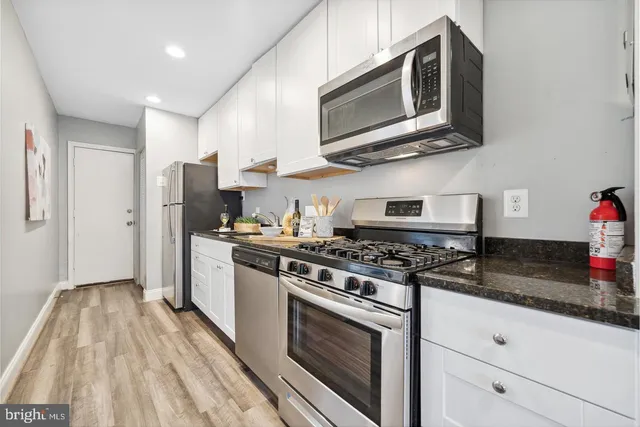 a kitchen with stainless steel appliances granite countertop a stove a refrigerator and a microwave