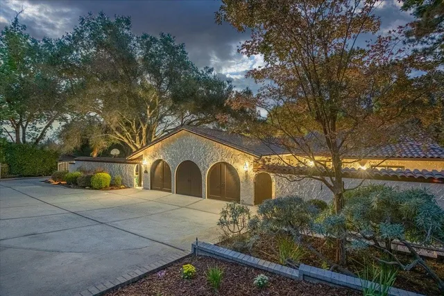 a view of a house with outdoor seating and a tree