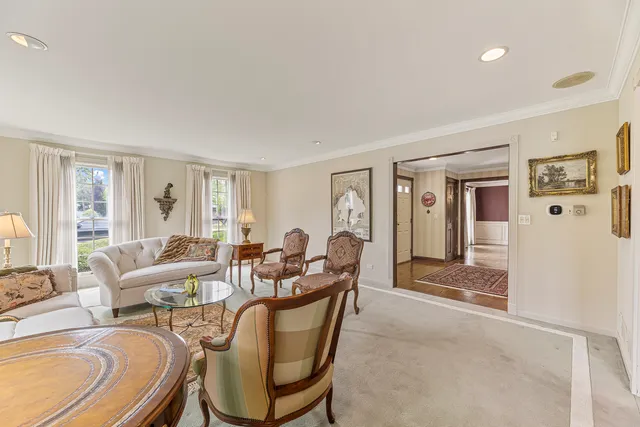 a living room with furniture a large window and wooden floor