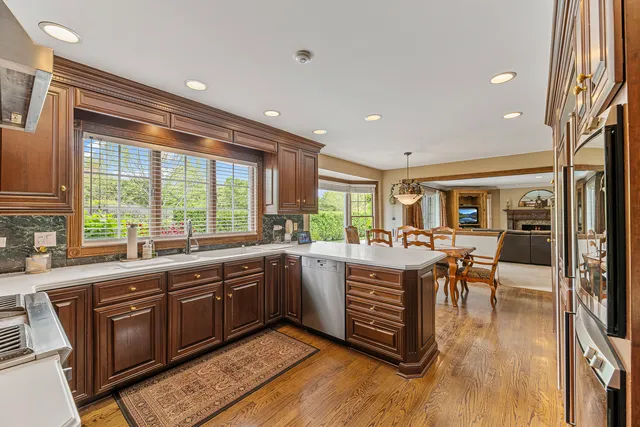 a large kitchen with stainless steel appliances granite countertop a stove and a view of living room