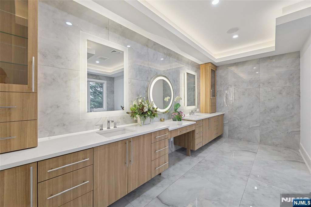 311 North Farview Avenue Paramus, NJ 07652 - Photo 24 of 50 a large bathroom with a double vanity sink a large mirror and a bathtub