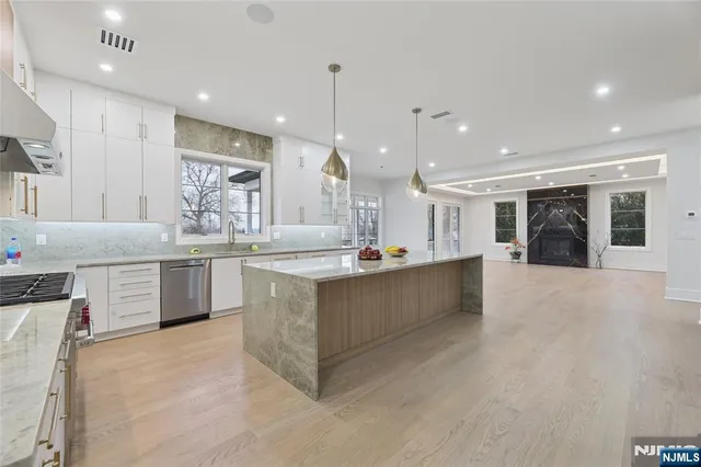 a kitchen with stainless steel appliances granite countertop a sink stove and cabinets