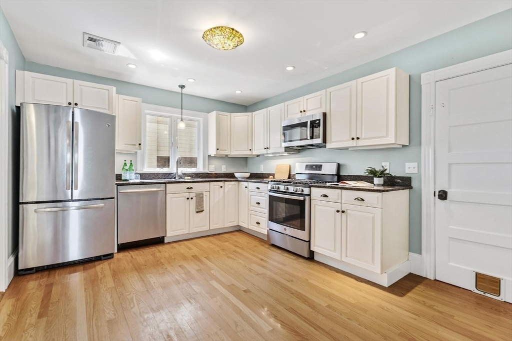 9 Governors Avenue, Unit 2 Winchester, MA 01890 - Photo 13 of 37 a kitchen with white cabinets and white appliances