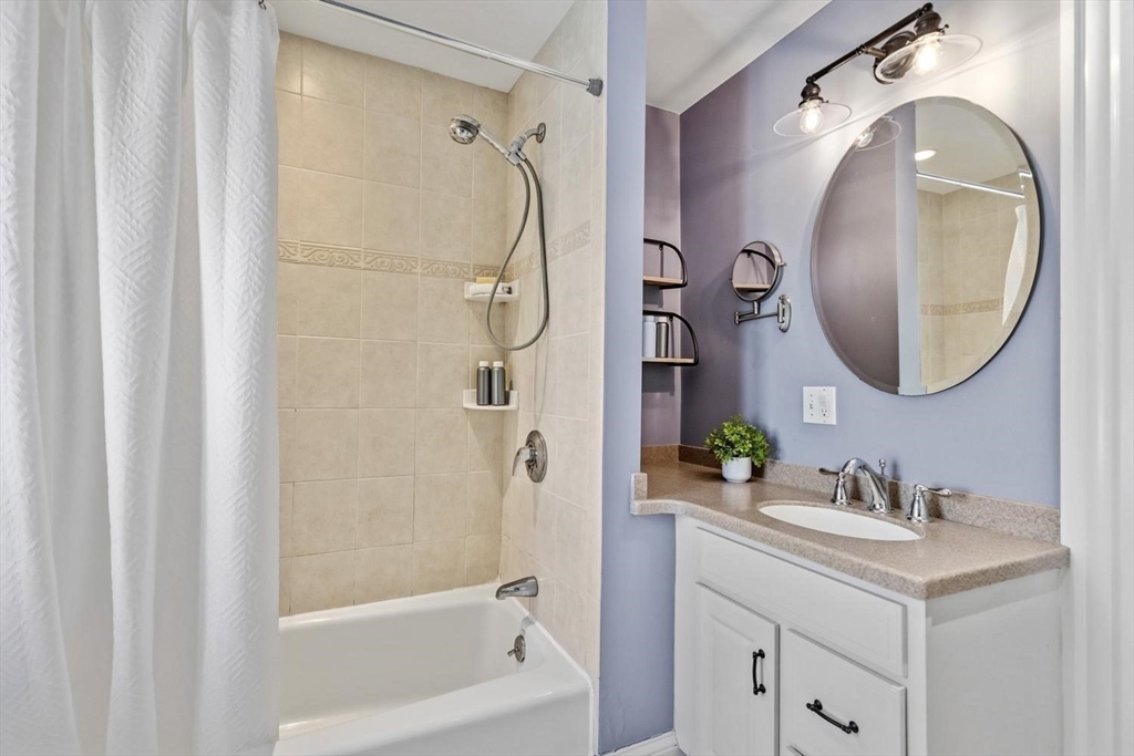 9 Governors Avenue, Unit 2 Winchester, MA 01890 - Photo 26 of 37 a bathroom with a sink a mirror a vanity and a shower
