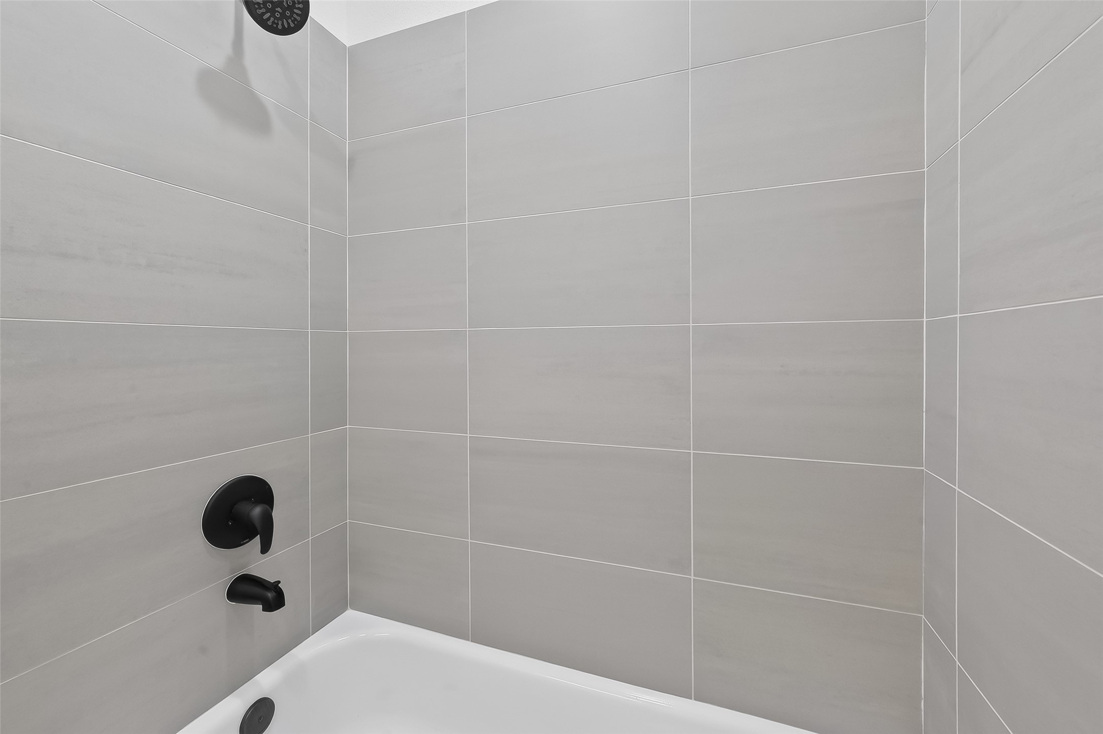 3514 Good Hope Street, Unit B Houston, TX 77021 - Photo 16 of 26 This bathroom features a modern shower with sleek gray tiles and matte black fixtures, offering a clean and contemporary look.