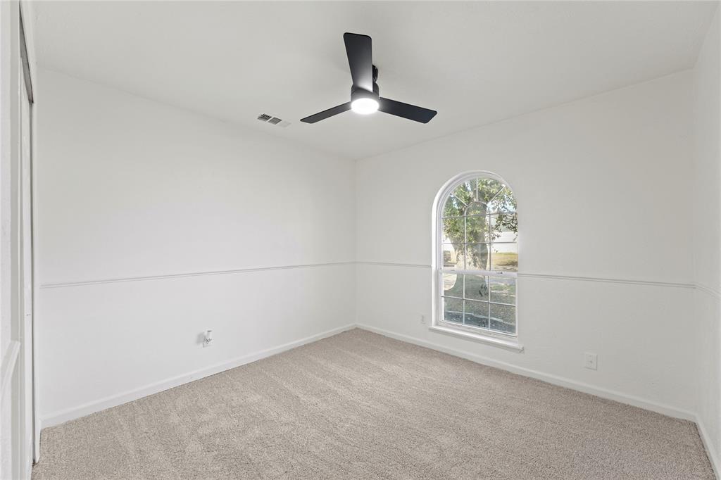5516 Maple Lane Rowlett, TX 75089 - Photo 16 of 18 an empty room with windows and ceiling fan