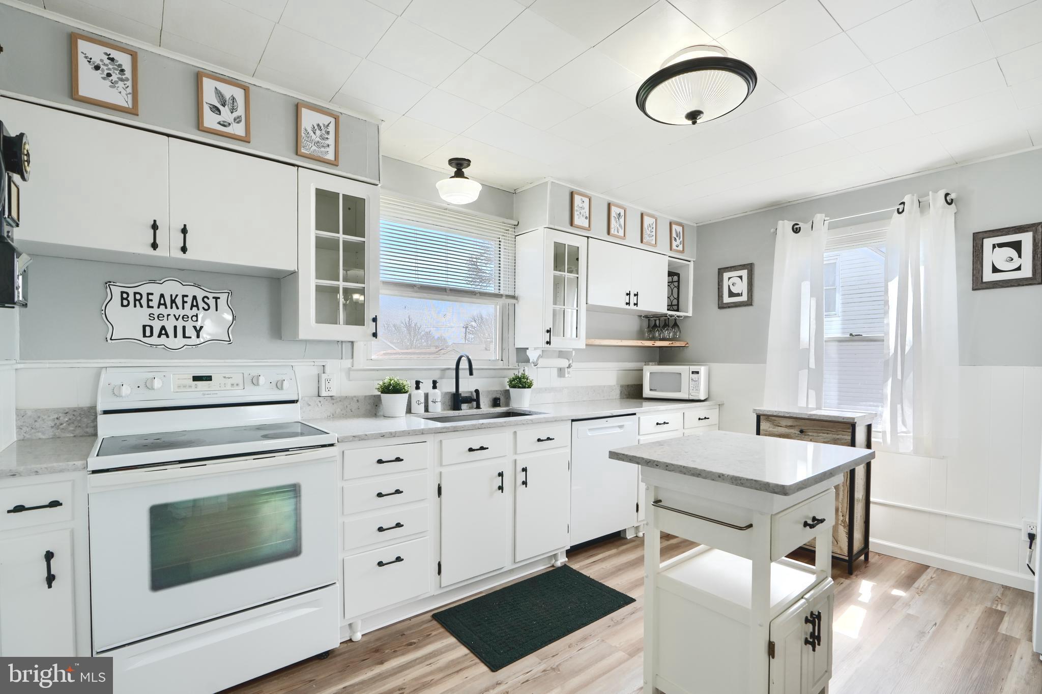 209 Middle River Road Baltimore, MD 21220 - Photo 9 of 35 a kitchen with white cabinets and white appliances