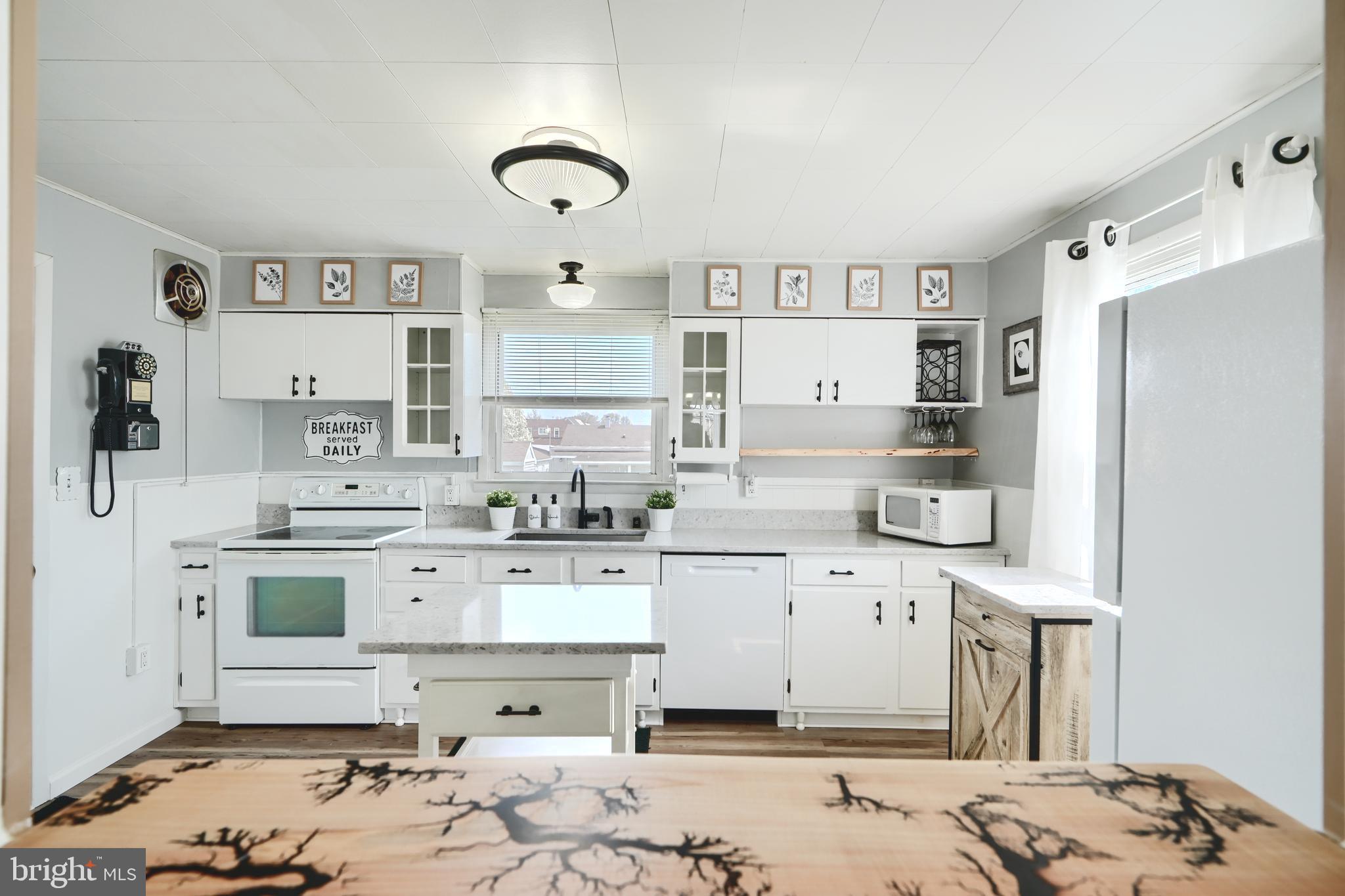 209 Middle River Road Baltimore, MD 21220 - Photo 10 of 35 a kitchen with kitchen island a sink a stove and cabinets