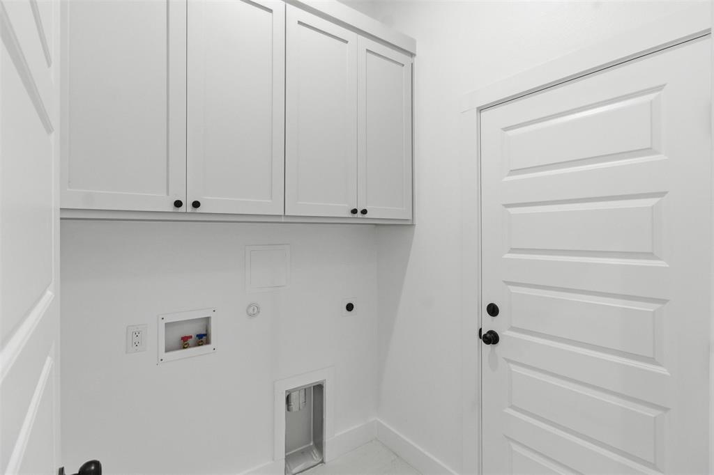 435 Waterboard Road Trinidad, TX 75163 - Photo 16 of 39 Bright laundry space featuring white shaker-style cabinetry with black hardware, a multi-panel interior door with black hardware, and utility hookups