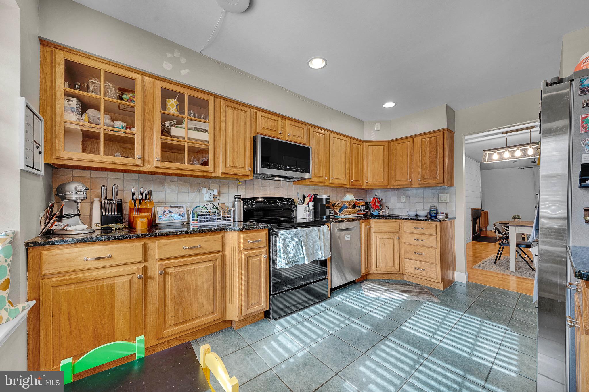 301 Cherokee Circle Ambler, PA 19002 - Photo 12 of 39 a kitchen with stainless steel appliances granite countertop a stove top oven a sink a dining table and chairs with wooden floor