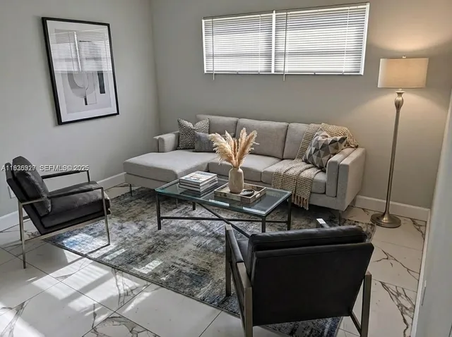 a living room with furniture a rug and a window