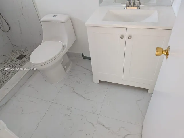 a white toilet sitting next to a bathroom sink