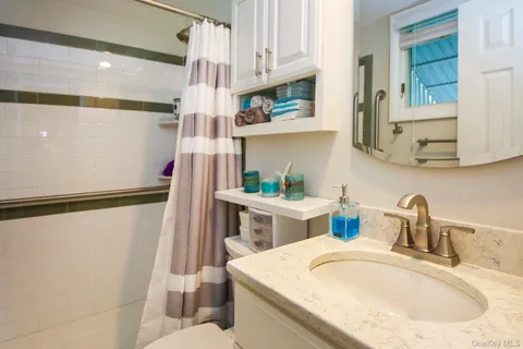 a bathroom with a sink a toilet and shower curtain