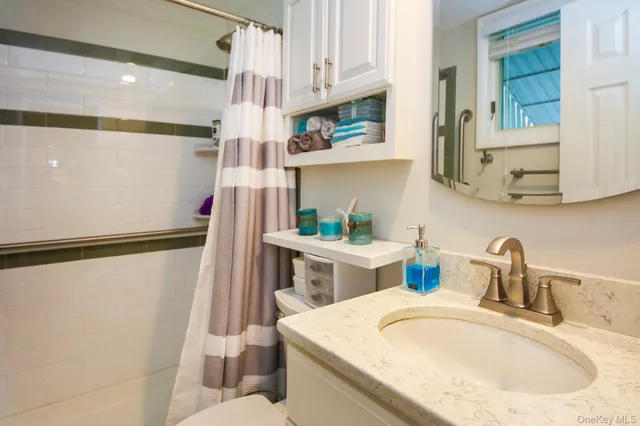 a bathroom with a sink a toilet and shower curtain