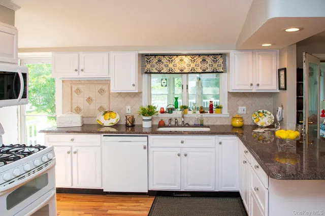 a kitchen with a white cabinets and window