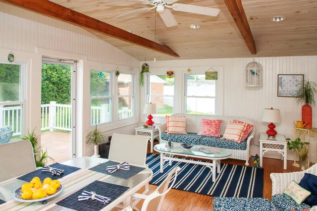 a living room with patio furniture and a flat screen tv