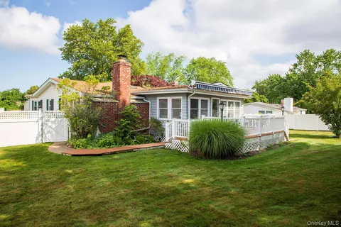 a front view of a house with a big yard and potted plants