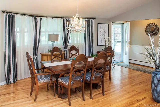 a dining room with furniture wooden floor and a chandelier